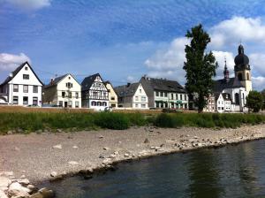 eine Reihe weißer Häuser neben einem Fluss in der Unterkunft Ferienwohnung Rheinblick Koblenz in Koblenz