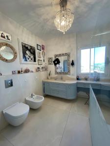 La salle de bains est pourvue de toilettes, d'un lavabo et d'un miroir. dans l'établissement Attico, à Viareggio