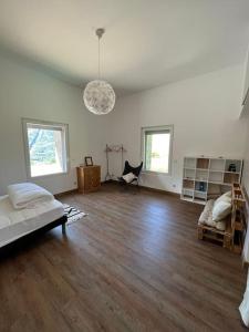 ein Wohnzimmer mit einem Bett und Holzboden in der Unterkunft Maisonnette des vignes in Albertville