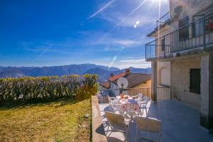 a patio with a table and chairs on the side of a building at Chalet Cademario - Happy Rentals in Cademario