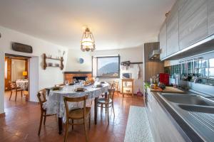 a kitchen with a table and a dining room at Chalet Cademario - Happy Rentals in Cademario