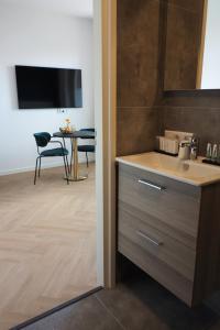 a bathroom with a sink and a table with a chair at Hotel 't Vertrek in Boxmeer