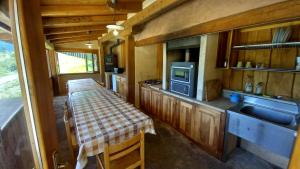 uma cozinha com uma mesa e um lavatório numa pequena casa em vallemaira house casa SAN SEBASTIANO gruppi 5 - 18 persone em San Damiano Macra