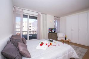 ein Schlafzimmer mit einem weißen Bett mit Blumen darauf in der Unterkunft Lugano Motta - Happy Rentals in Lugano