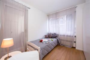 ein kleines Schlafzimmer mit einem Bett und einem Fenster in der Unterkunft Lugano Motta - Happy Rentals in Lugano