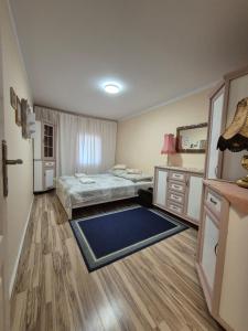 a bedroom with two beds and a blue rug at Apartament Zającówka - centrum miasta w leśnej enklawie in Szklarska Poręba