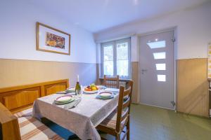 una sala da pranzo con tavolo e piatto di frutta di Casa Salogni - Happy Rentals a Maggia