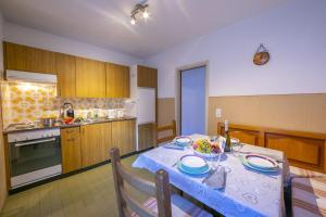 une cuisine avec une table et un chiffon bleu dans l'établissement Casa Salogni - Happy Rentals, à Maggia