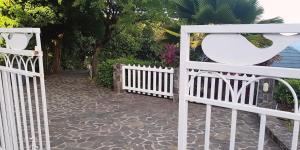 a white fence with a stone walkway next to a driveway at Seacliff in Bequia