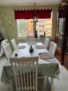 een eettafel met witte stoelen en een tafel en een stoel bij 2 sovrum i en del av lägenheten in Stockholm