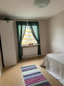 a bedroom with a bed and a window and a rug at 2 sovrum i en del av lägenheten in Stockholm