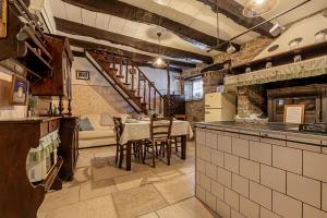 - une cuisine avec une table et des chaises dans la chambre dans l'établissement Istrian Stone House With Hot Tub - Happy Rentals, à Gračišče