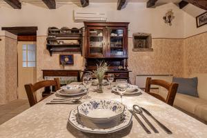 une salle à manger pourvue d'une table avec des assiettes et de l'argenterie dans l'établissement Istrian Stone House With Hot Tub - Happy Rentals, à Gračišče