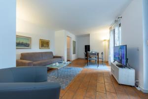a living room with a couch and a tv at Casa Chiara - Happy Rentals in Locarno