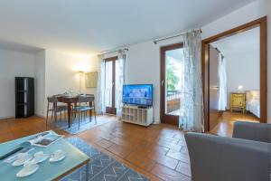 sala de estar con sofá, mesa y TV en Casa Chiara - Happy Rentals, en Locarno