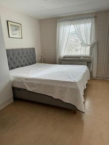 a bedroom with a large bed and a window at 2 sovrum i en del av lägenheten in Stockholm