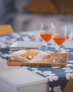 two glasses of wine and a plate of food on a table at C'era una Volta Apartments in Bisceglie