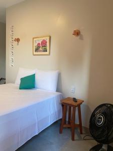 um quarto com uma cama branca e uma mesa em Pousada Mãe Natureza em Pirenópolis