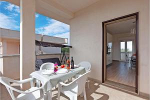 a dining room with a table and white chairs at Le Bianche Apartment 4 close to the beach - Happy Rentals in San Pietro in Bevagna