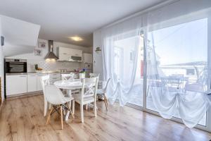 una cucina e una sala da pranzo con tavolo e sedie di Pool House Edita - Happy Rentals a Bribir