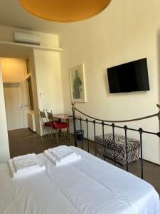 een slaapkamer met een bed en een flatscreen-tv bij PB suites in Florence