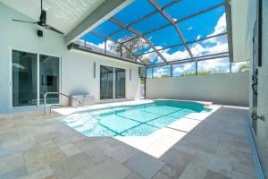 - une piscine dans une maison dotée d'un plafond en verre dans l'établissement Newly Remodeled 4BR/3BA, Private Pool, Sleeps 8, à Port Charlotte