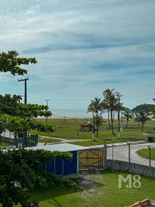 Blick auf einen Park mit dem Meer im Hintergrund in der Unterkunft Cantinho do Mar Pousada in Bertioga
