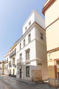a white building on the side of a street at Casa Señorial del Siglo XVIII in Seville