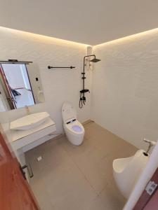 a white bathroom with a toilet and a sink at Jay's Villa 2 (Friendship) in Angeles