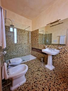 a bathroom with two toilets and a sink at Relais Vimercati in Crema