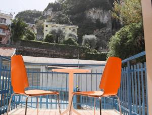 2 orangefarbene Stühle und ein Tisch auf dem Balkon in der Unterkunft Il Sirenio in Sorrent
