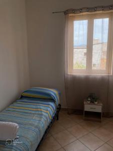 Posto letto in camera con finestra e tavolo di Casa Vacanza Accetta a Trappeto