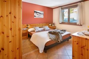 um quarto com uma cama grande e uma janela em Chalet Primula 11 em Santa Caterina di Valfurva
