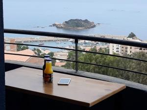 a bottle of beer sitting on a table on a balcony at Immeuble Thala Tigzirt in Tigzirt