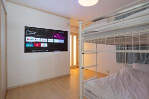 1 dormitorio con litera y TV en la pared en Kagurazaka City House - 神楽坂シティハウス en Tokio