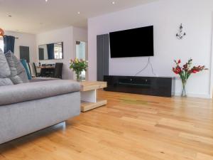 a living room with a couch and a flat screen tv at Blue Bay Villa in Holyhead