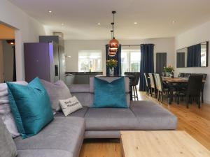 a living room with a gray couch with blue pillows at Blue Bay Villa in Holyhead