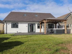 a house with a pavilion on a lawn at Blue Bay Villa in Holyhead