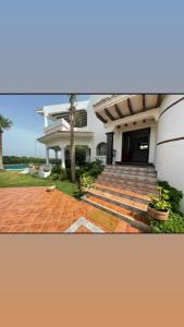 una casa blanca con escaleras y una palmera en Villa Marina Smir avec piscine, en Tetuán