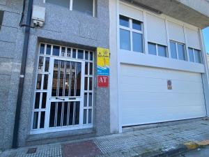 una puerta de garaje con una señal de salida delante de ella en dp Sarria Centro, en Sarria