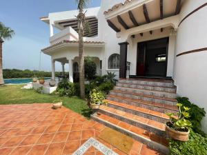 una casa con una escalera que conduce a la puerta principal en Villa Marina Smir avec piscine, en Tetuán