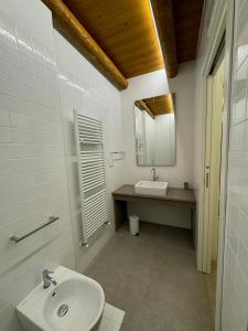 ein weißes Badezimmer mit einem Waschbecken und einem Spiegel in der Unterkunft Villa Riva in Badia Calavena