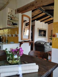 a kitchen with a table with a vase of flowers on it at Cabaña los cerezos in Ubaté +31 photos