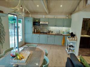 a kitchen with blue cabinets and a glass table at Isidaura in Zutendaal