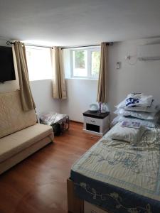 een slaapkamer met een bed en een bank erin bij Newly renovated 2 Bed ground floor flat in Haskovo in Tŭnkovo
