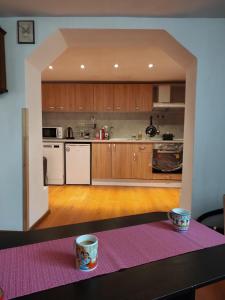 een keuken met houten kasten en een tafel met een roze tapijt bij Newly renovated 2 Bed ground floor flat in Haskovo in Tŭnkovo