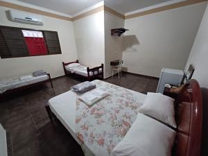 a bedroom with a bed and a chair in it at HOTEL TABARANA in Ubarana