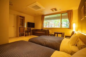 旭川市にあるMorinoyu Hotel Hanakaguraのベッドルーム1室(ベッド2台付)、リビングルームが備わります。