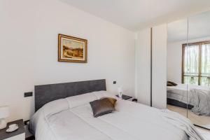 Cava ManaraにあるCasa Maddalena - Pavia, Cava Manara - by HOST4Uの白いベッドルーム(ベッド2台、鏡付)