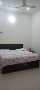 Murli Manohar Palace في فريندافان: غرفة نوم بسرير كبير مع بطانية وردية